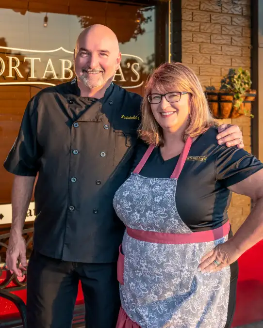 Pam and Rich Lee Owners of Portabellas standing out front of restaurant together.